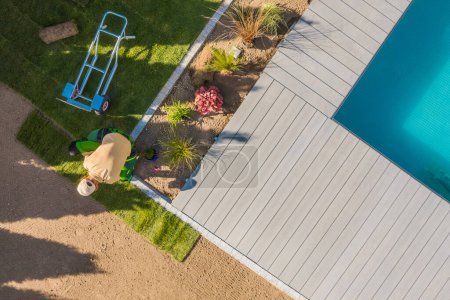 Photo for Professional Landscaper Installing Roll Out Lawn Around Outdoor Swimming Pool. Residential Backyard Garden Landscaping Work in Progress. Aerial View - Royalty Free Image