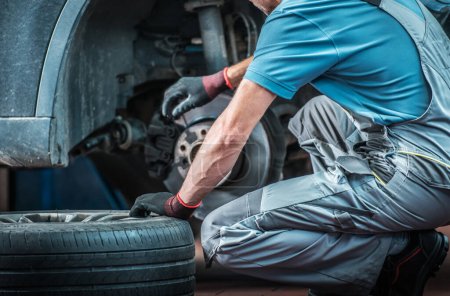 Photo for Caucasian Mechanic Changing Tires on Car in His Auto Workshop During Scheduled Seasonal Change. Vehicle Care and Maintenance Theme. - Royalty Free Image