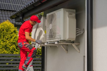 Photo for Professional Caucasian HVAC Worker in His 40s Performing Heat Pump and Air Condition Units Seasonal Maintenance - Royalty Free Image