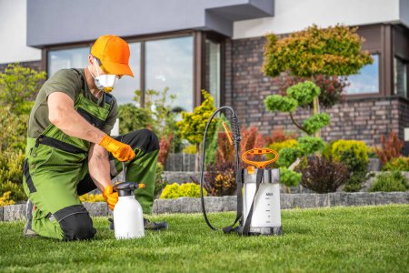 Professional Landscaper Preparing His Pest Control Equipment Before Spraying Pesticide to Protect Plant. Garden Care and Maintenance Theme.