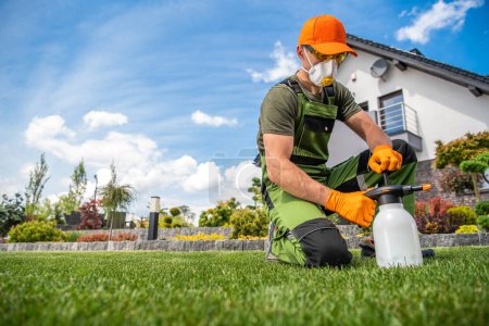 Photo for Professional Gardener Wearing Full Face Mask and Safety Glasses Getting Ready to Apply Pesticides on the Lawn Grass with One Handed Pump Sprayer. - Royalty Free Image