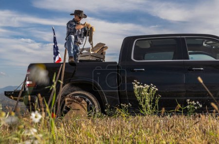 Téléchargez les photos : Cowboy Rancher Preparing Ropes on Back of His Pickup Truck While Working on His Ranch. Countryside Theme. - en image libre de droit