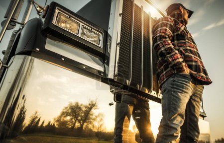 Foto de Ground Transportation Semi Truck Driver Job Concept. Caucasian Trucker in Front of His Vehicle. - Imagen libre de derechos