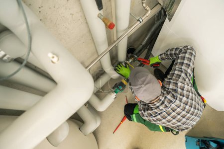 Foto de Plumbing Job Performed by Professional Plumber HVAC Technician. Residential Air and Water Heating Systems. - Imagen libre de derechos