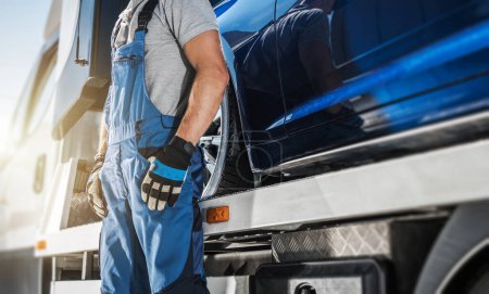 Téléchargez les photos : Professional Towing Truck Driver Staying Next To His Vehicle. Lower Body Part Close Up. Transportation Industry. - en image libre de droit