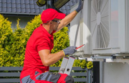 Téléchargez les photos : Professional AC Technician Performing Regular Maintenance Check of Residential Air Conditioning External Unit. - en image libre de droit