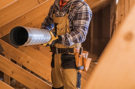 Téléchargez les photos : HVAC Worker Installing Attic Air Duct in a Residential Building. Heating and Cooling Technologies. - en image libre de droit