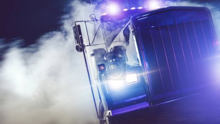 Téléchargez les photos : American Classic Semi Truck Drive Out of Smoke la nuit. Thème des camionneurs. - en image libre de droit
