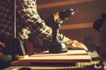 Photo for Closeup of Cordless Electric Screwdriver on the Background of Woodworking Workshop. Construction Power Tools and Equipment Theme. - Royalty Free Image
