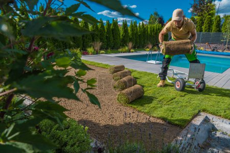 Photo for Caucasian Landscaping and Gardening Worker in His 40s Installing Fresh Lawn Made From Natural Grass Turfs. - Royalty Free Image