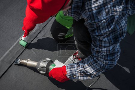 Photo for Caucasian Roofing Worker in His 40s. Hot Air Blower Using For EPDM Roof Membrane Rubber Installation - Royalty Free Image