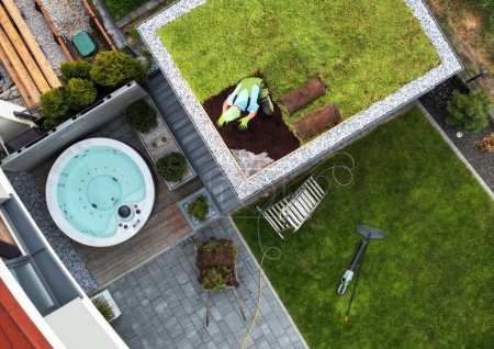 Perennial Succulents Sedum Green Roof Building Aerial View. Caucasian Technician Finishing Green Roof Installation