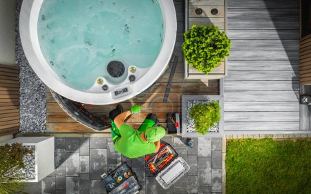 Aerial View of Hot Tub Technician Performing Garden SPA Repair During Seasonal Maintenance