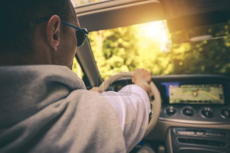 Téléchargez les photos : Conducteur caucasien dans les lunettes de soleil bénéficiant d'une conduite de véhicule convertible pendant la soirée chaude d'été - en image libre de droit