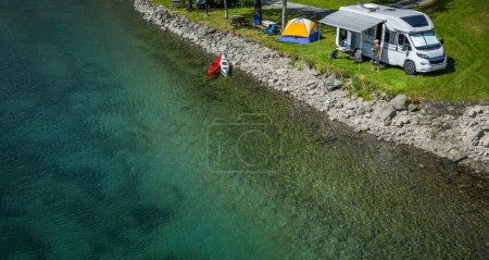 Foto de Vista aérea de un parque de caravanas frente al agua. Camper Van y una tienda al lado de Crystal Clear Glacial River - Imagen libre de derechos