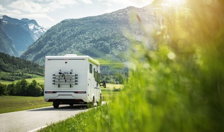 Foto de Volver Vista de White Camper Van Conduciendo hacia el hermoso paisaje montañoso de verano. Motorhome Traveling Theme. - Imagen libre de derechos