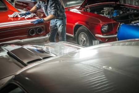 Téléchargez les photos : American Classic Cars Collection Propriétaire Nettoyage de ses voitures de rêve dans un magasin. - en image libre de droit