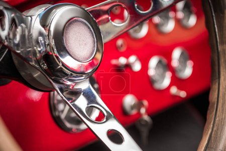 Photo for Automotive Theme. Classic Car Elegant Red Dashboard with Chromed Switches and Stainless Steering Wheel - Royalty Free Image