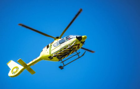 Téléchargez les photos : Un hélicoptère ambulancier jaune reçoit un appel d'urgence. Ciel bleu clair. - en image libre de droit