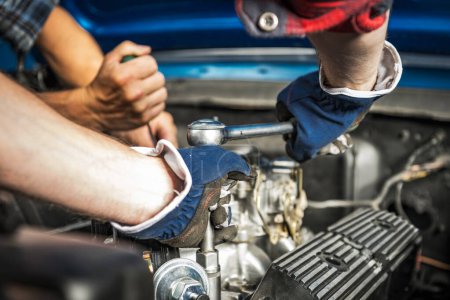 Téléchargez les photos : Deux mécaniciens professionnels caucasiens de voiture effectuant la réparation de moteur à essence - en image libre de droit