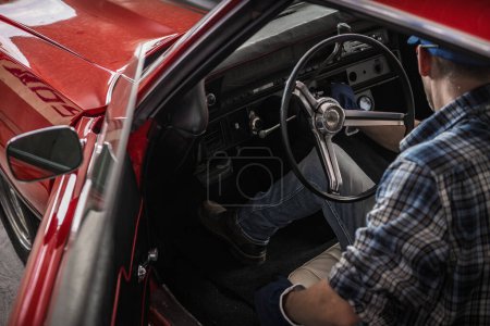 Téléchargez les photos : Caucasien professionnel classique mécanicien de voitures dans sa quarantaine à l'intérieur restauré American Muscle Car - en image libre de droit