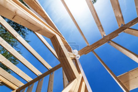 Téléchargez les photos : Wood Made House Skeleton Frame Building and the Blue Sky. Thème chantier de construction. - en image libre de droit