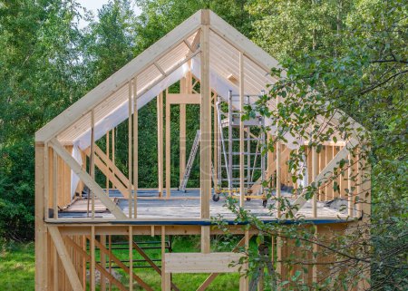 Foto de Estructura de esqueleto de madera de nueva construcción de una casa ubicada entre árboles. Vista aérea. - Imagen libre de derechos