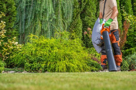 Foto de Hombre caucásico en su 40s limpieza su patio trasero usando jardín vacío - Imagen libre de derechos
