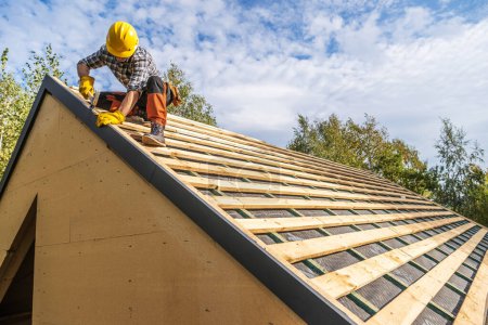 Téléchargez les photos : Professionnel Caucasien Travailleur de la construction portant un chapeau dur Assemblage d'éléments en bois sur le toit - en image libre de droit
