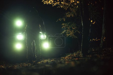 Foto de A Man in Front of His Four Wheeler During Night Hours. Tema Off Roading. - Imagen libre de derechos