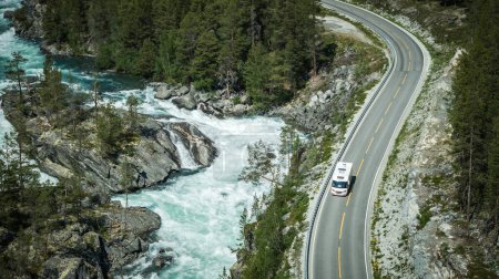 Téléchargez les photos : Camper Van moderne sur une route norvégienne panoramique le long de la rivière. Véhicule récréatif Road Trip thème. - en image libre de droit