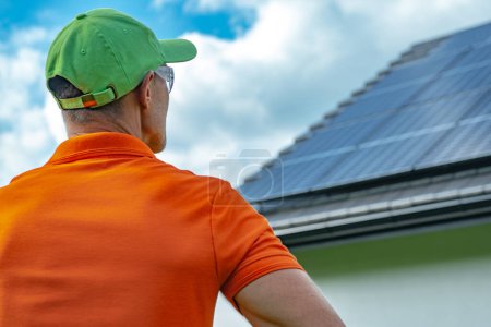 Foto de Instalador de paneles solares profesionales caucásicos que da el último vistazo final a un sistema fotovoltaico recién instalado. - Imagen libre de derechos