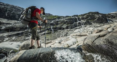 Téléchargez les photos : Sac à dos caucasien lors d'une randonnée explorant le paysage glaciaire norvégien - en image libre de droit