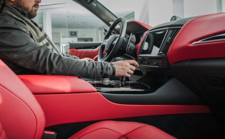 Photo for Car Buyer Checking on the Vehicle Elegant Red Leather Interior. Exotic Car Purchase. - Royalty Free Image