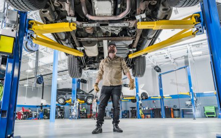 Photo for Car Dealer Auto Service Mechanic Checking Vehicle Undercarriage Looking For Issues - Royalty Free Image