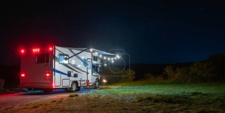 Téléchargez les photos : Camping-car moderne de classe C sous le ciel étoilé. Thème de voyage VR. - en image libre de droit