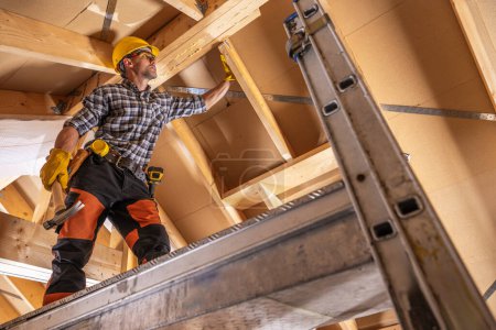 Foto de Trabajador de contratista de construcción en un andamio que realiza ensamblaje de elementos de techo - Imagen libre de derechos