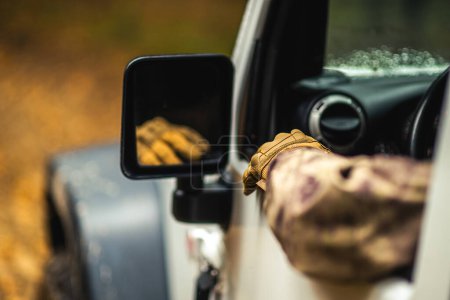 Téléchargez les photos : Chasseur d'animaux portant le camouflage conduisant le long de la nature sauvage à la recherche d'un jeu - en image libre de droit