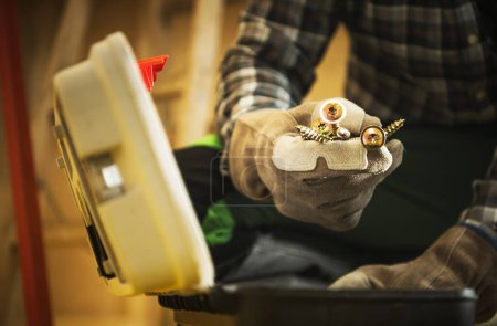Foto de Obrero constructor con tornillos metálicos en la mano - Imagen libre de derechos