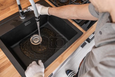 Téléchargez les photos : Technicien en plomberie Installation d'un évier de cuisine et d'un robinet. Vérification de l'approvisionnement en eau. - en image libre de droit