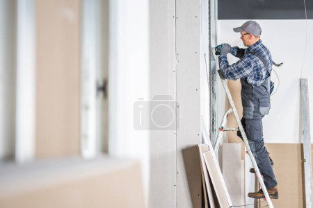 Foto de Pro Construction Site Contractor Worker Building Drywall Walls. Acabado interior. - Imagen libre de derechos