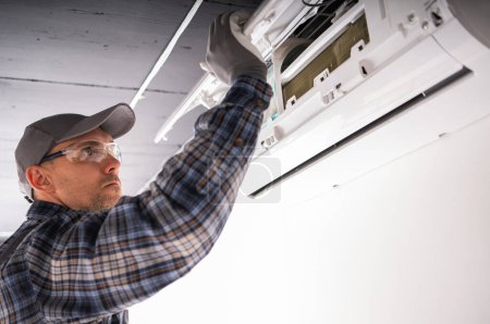 Téléchargez les photos : Technicien en chauffage et refroidissement effectuant l'unité de séparateur de climatisation - en image libre de droit