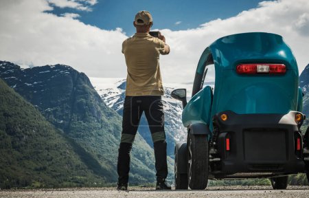 Kaukasischer Tourist in seinen Vierzigern erkundet norwegische Vestland-Region mit kleinen Elektrofahrzeugen