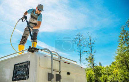 Téléchargez les photos : Un homme qui lave le camping-car Van Roof. Thème Propriété des VR. - en image libre de droit
