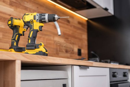 Photo for Home Kitchen Remodeling Theme. Two Drill Drivers Power Tools on the Kitchen Counter Top. - Royalty Free Image