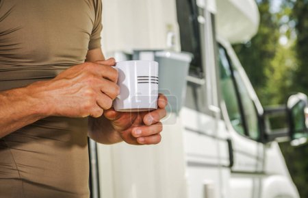 Téléchargez les photos : Homme caucasien avec une tasse de café dans ses mains rester à côté de son camping-car Van RV Motor Home et profiter du moment - en image libre de droit
