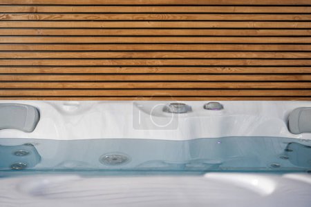 Photo for Modern Hot Tub and the Wooden Lamellas Wall Close Up Photo - Royalty Free Image