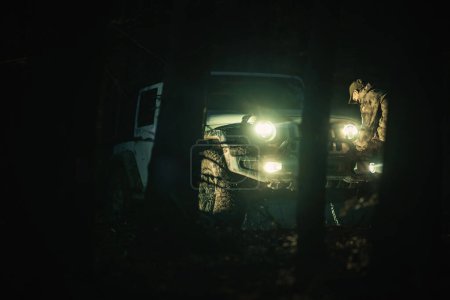 SUV driving amidst trees at night.