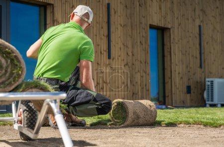 Photo for Landscaping worker installing grass in front of a house. - Royalty Free Image