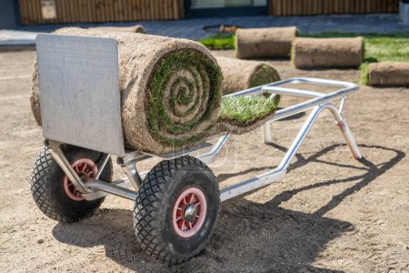 Photo for Cart carrying roll of grass turfs within landscaped area - Royalty Free Image